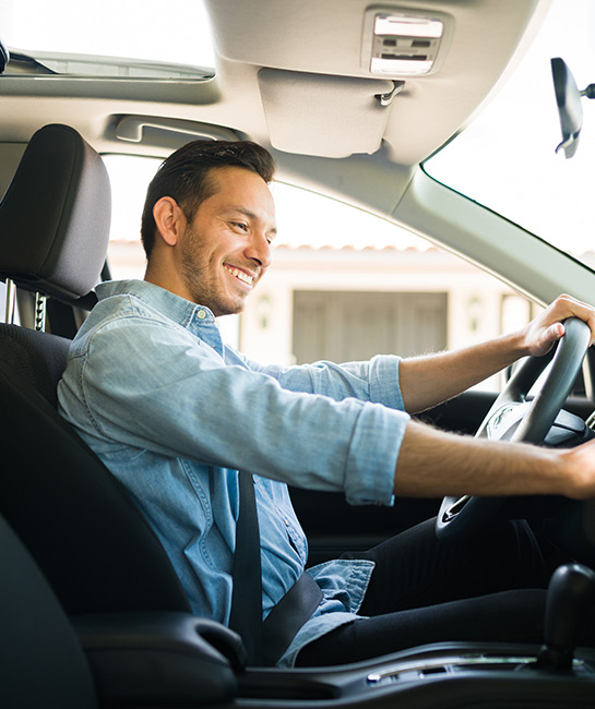 Man in new car pushing buttons on the dash smiling