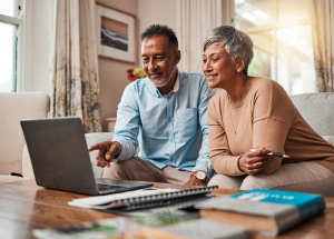 Mature couple using laptop in living room 