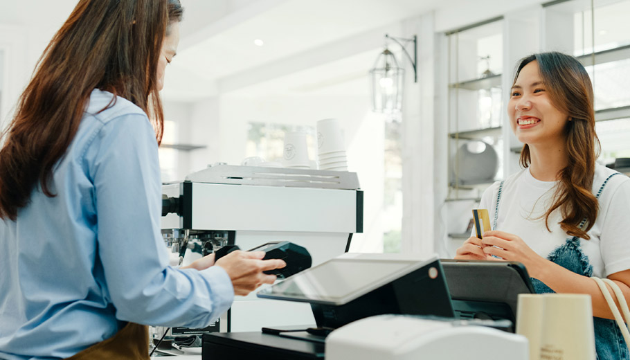 Woman paking contactless payment with credit card