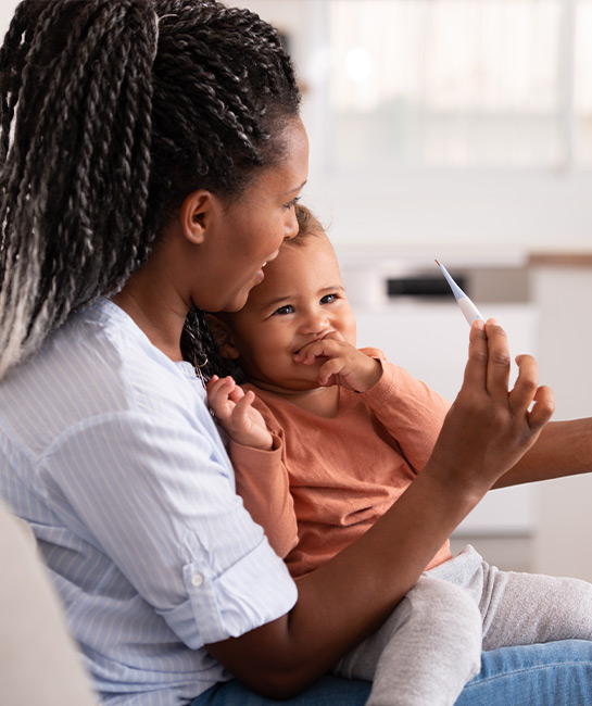 Mother holding thermometer and her baby on a virtual doctor visit 