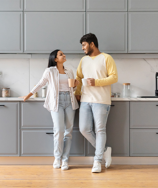 Young couple looking at each other and smiling in new kitchen