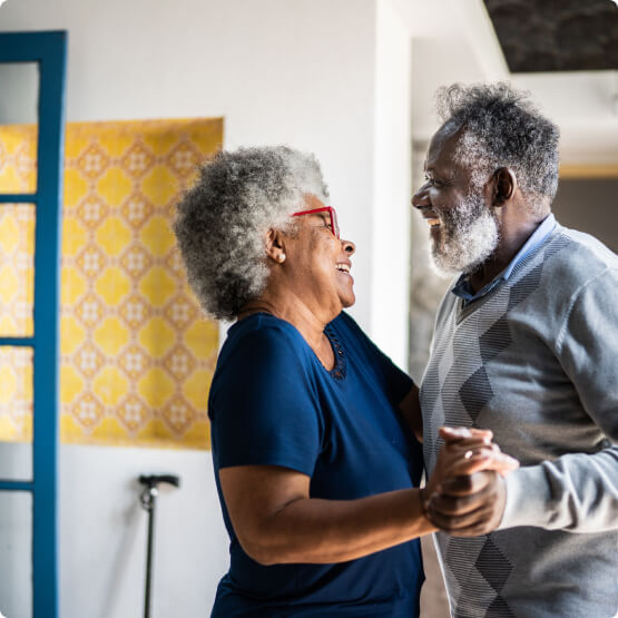 Mature couple dancing in home