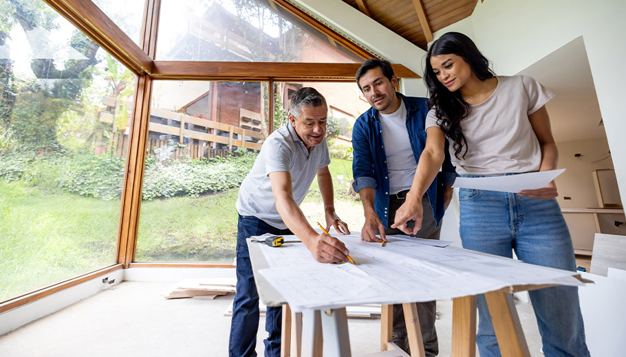 Couple with contractor discussing renovation or construction plans for their home